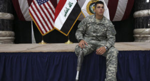 A US soldier with a prosthetic leg sits on the stage as he attends a ceremony for US soldiers who sustained combat injuries in Iraq in Baghdad